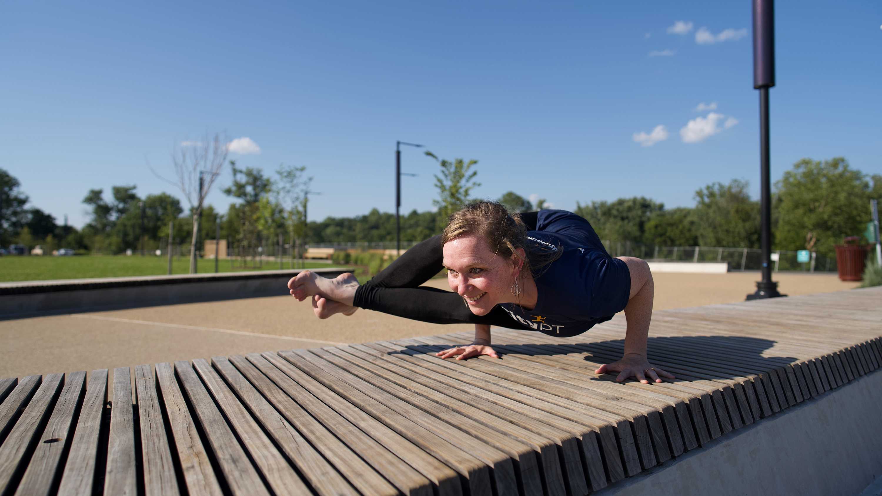 Woman performing an eight angle yoga pose (astavakrasana)