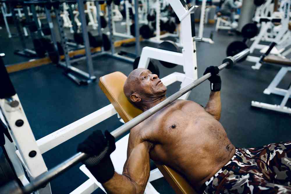 Man doing bench press with bar lowered to chest