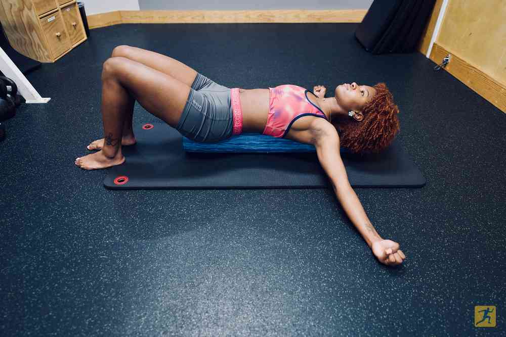 Woman performing a supine chest stretch exercise