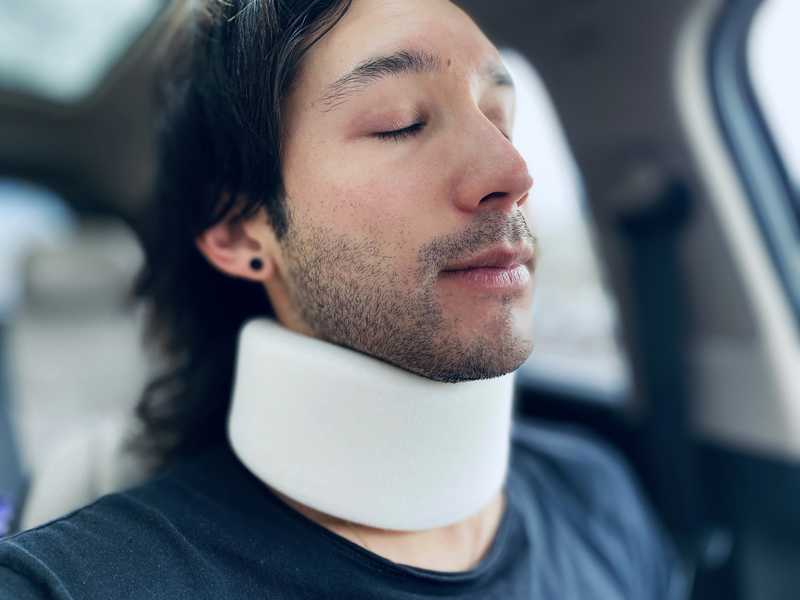 Man with injured neck sitting in car with neck brace on. Avoid injuries like this by avoiding DIY physical therapy.