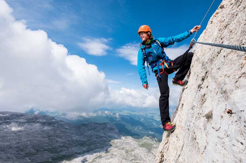 Exhilarated man climbing mountain